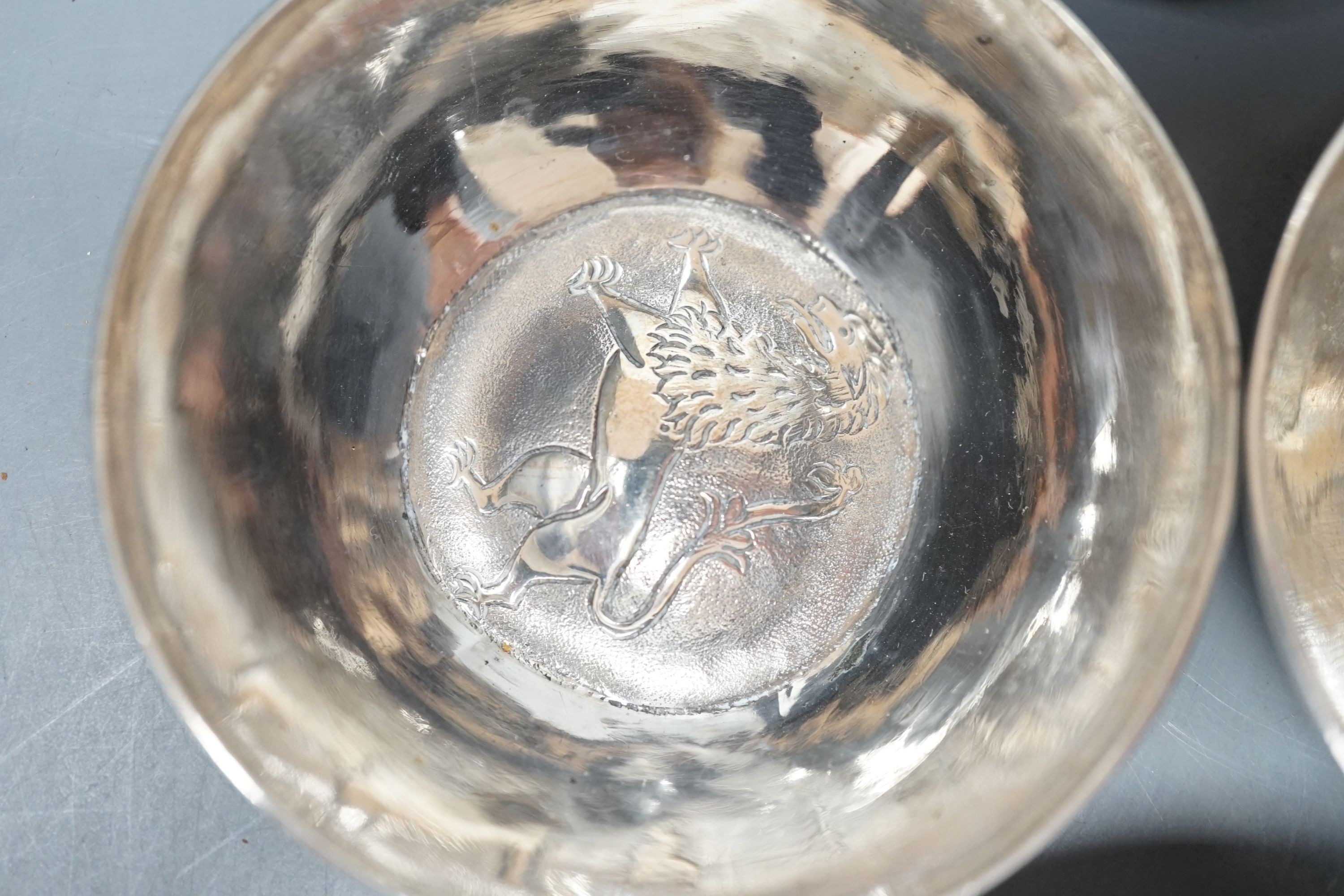 Four small Rangoon white metal bowls together with a simile basket and six small white metal bowls with heraldic motifs, gross 24.5oz.
